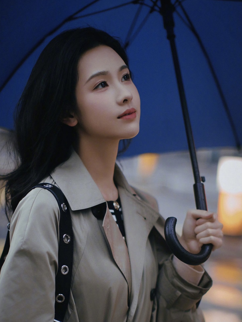 陈都灵雨中散步氛围感满满 风衣蓝伞显文艺气质